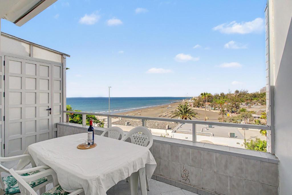 a balcony with a table and chairs and the ocean at A la Playa en San Agustín in Maspalomas