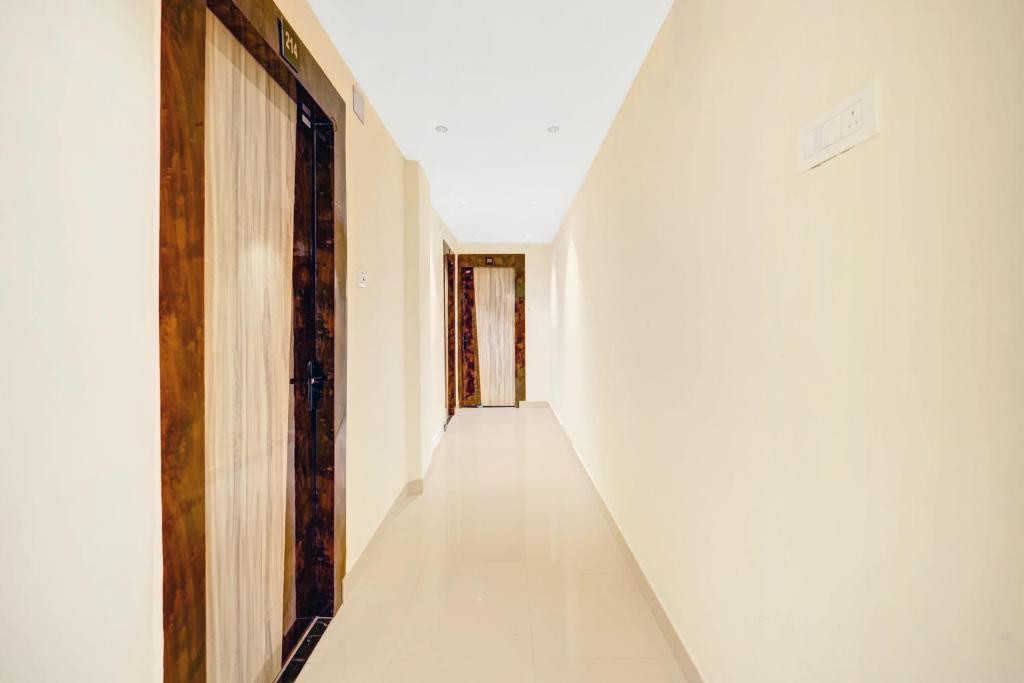 an empty corridor of a white building with a door at HOTEL O DIVIRA INN in Dhanbād
