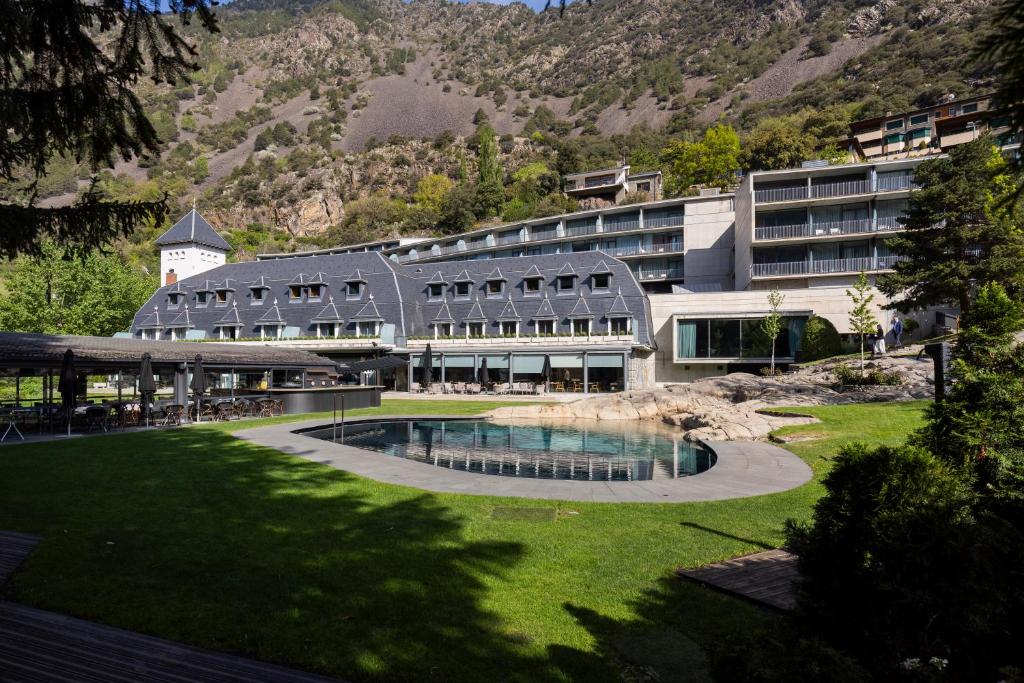 a large building with a swimming pool in the grass at Andorra Park Hotel in Andorra la Vella