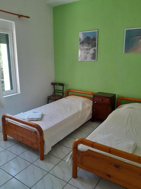 two beds in a room with green walls at makis in Xilosírtis
