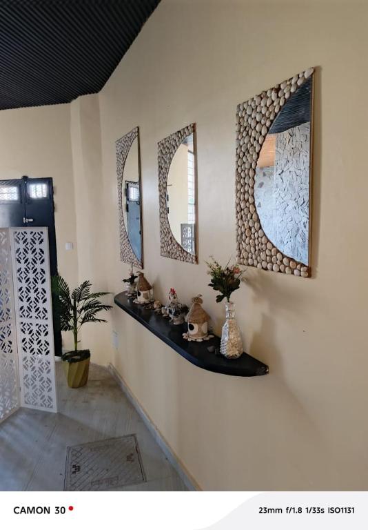 a room with two mirrors on a wall with a shelf at Galle subalbe in Pikine
