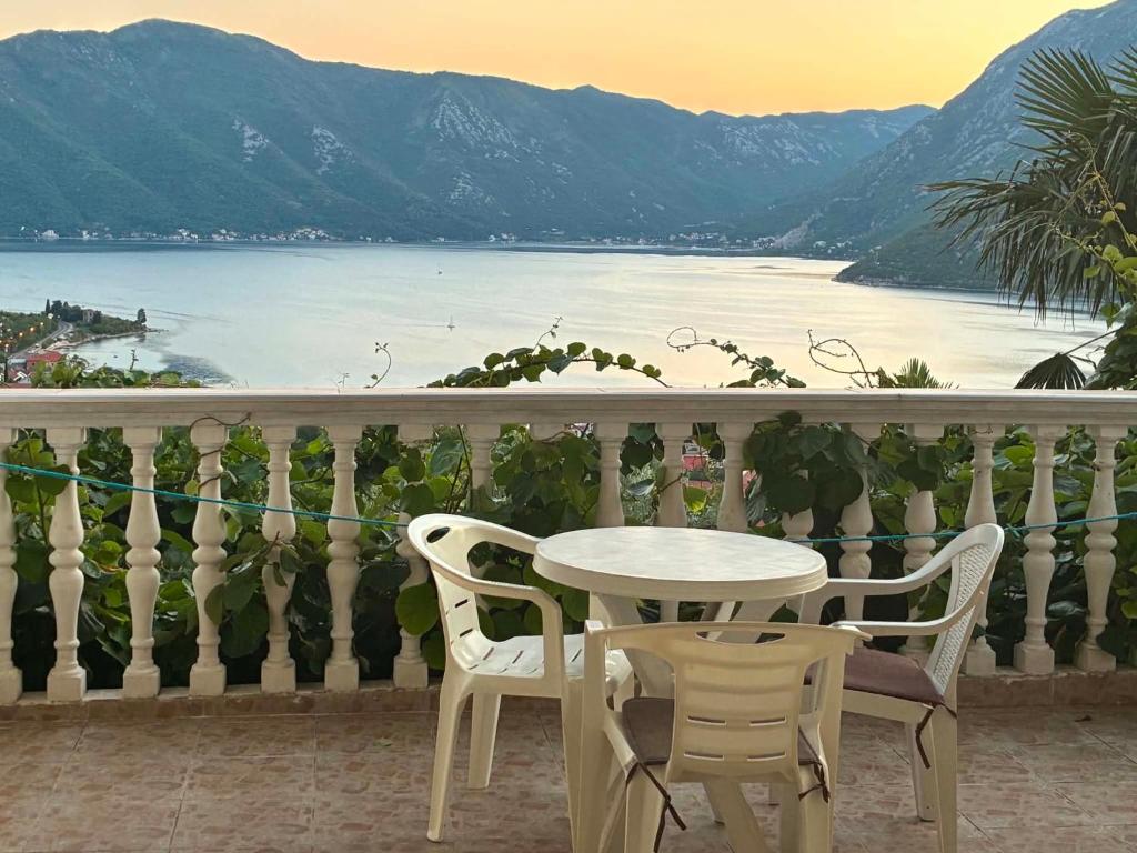 a table and chairs on a balcony with a view of the water at Vista View Apartments in Risan