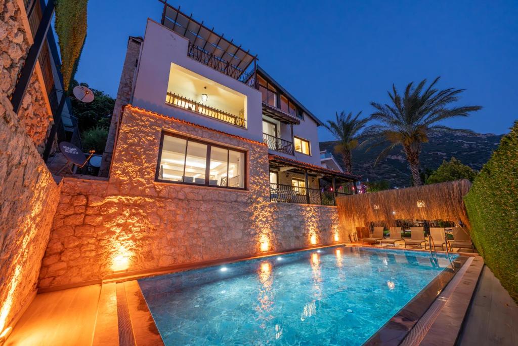 a house with a swimming pool in front of a building at Villa Elfuze in Kalkan