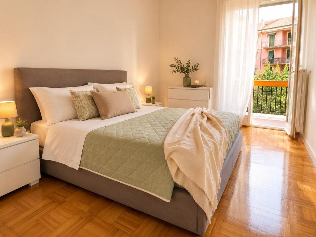 a large bed in a bedroom with a large window at Quick Home Victoria in Biella