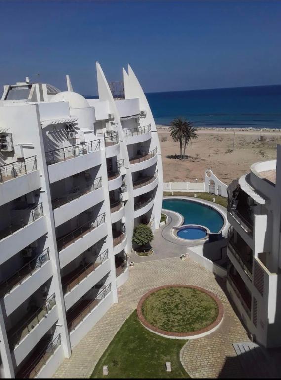 a view of two apartment buildings next to the beach at Ninou diamants in Harqalah