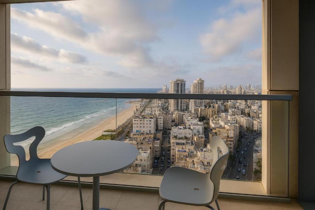 a balcony with a table and chairs and a view of the ocean at AREAN Hotel Bat Yam in Bat Yam