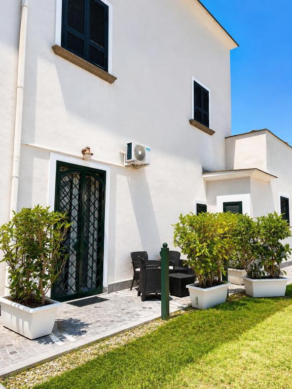a white building with a door and some plants at Casa Corallium in Torre del Greco