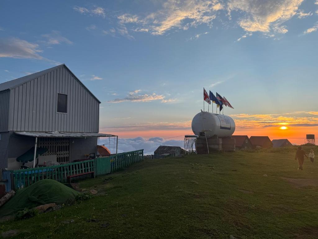 a barn and a building with flags on top of it at Gomismta Sky House in Gomi