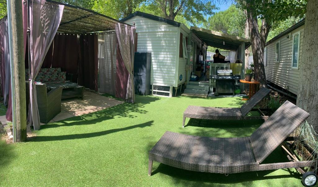 a yard with two chairs and a shed at Mobile Home Agde Les Sables D'or in Le Grau-dʼAgde