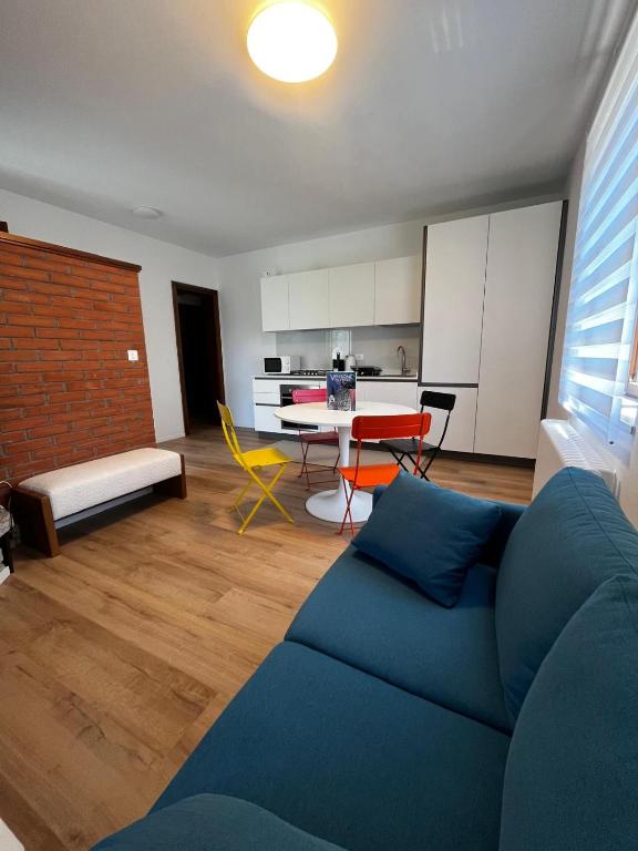 a living room with a blue couch and a table at A lì dai Nûtis in Venzone