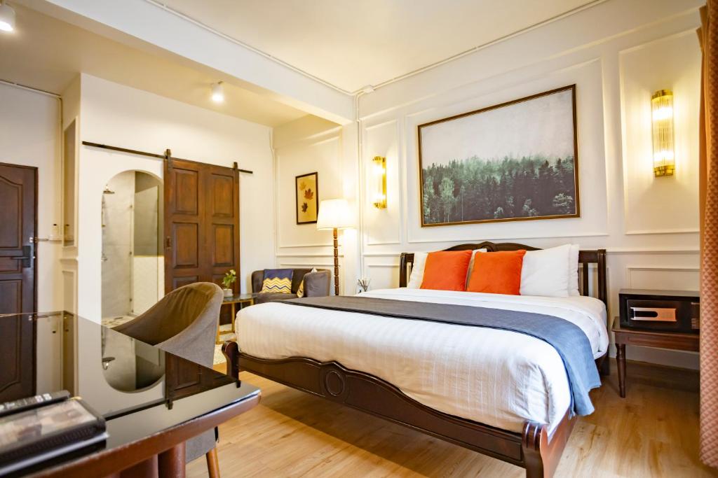 a bedroom with a large bed with orange pillows at Na Vayla PaPlern in Bangkok