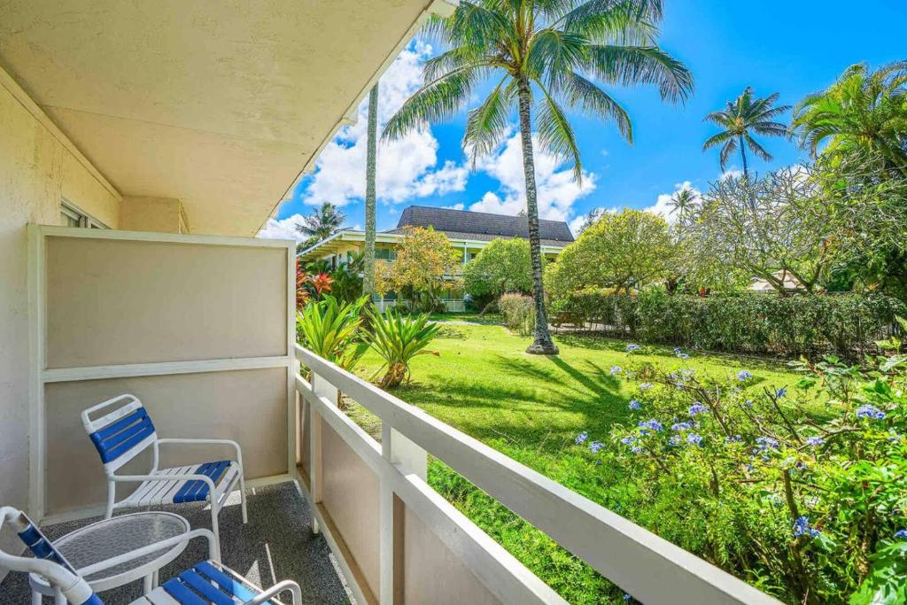 a balcony with chairs and a view of a yard at Ideal Coconut Coast Condo in Kapaa