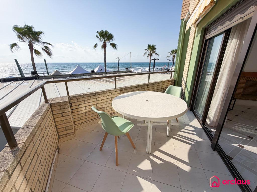 a table and chairs on a balcony overlooking the beach at Poble Mar 2 in Oropesa del Mar