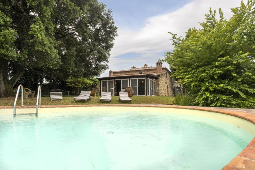 an empty swimming pool in front of a house at Casale Bianca Luce in Santa Luce