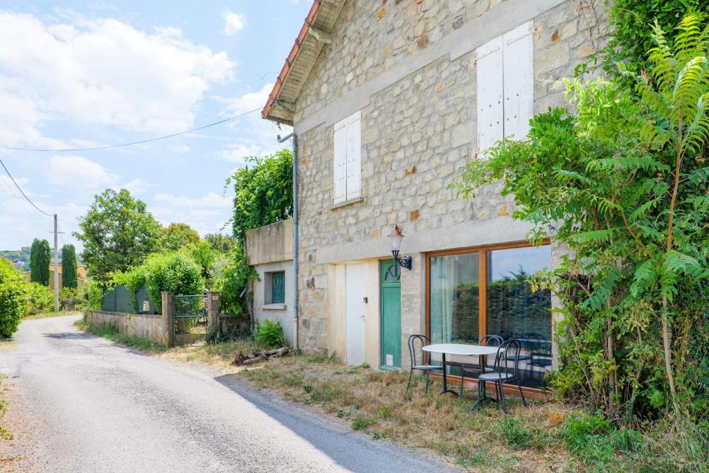 a stone building with a bench next to a road at Appartement de charme en Ardèche in Aubenas
