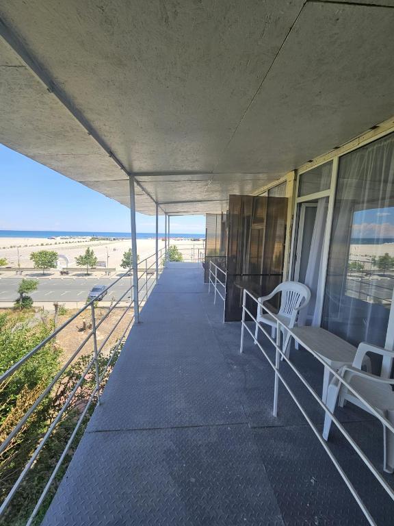 a building with a porch with chairs and the beach at Complex GEC-HISTRIA Mamaia in Mamaia