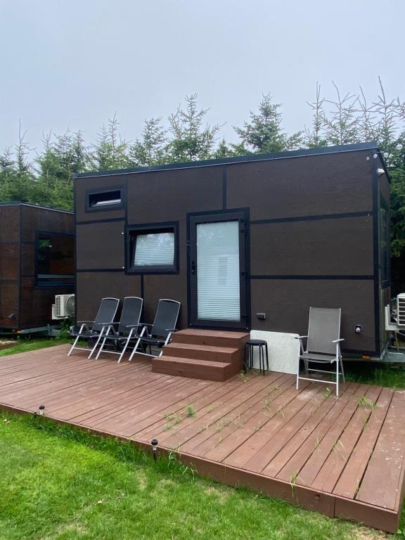 a trailer with chairs and a table on a deck at Domek Surf Camp in Jastarnia