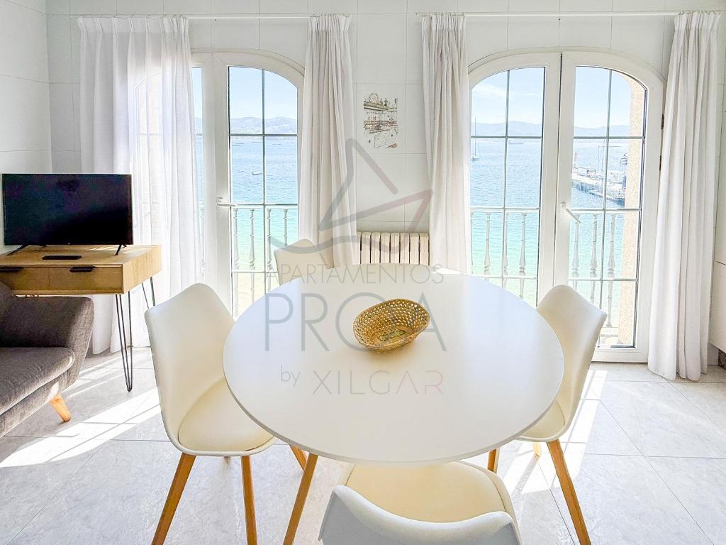 a living room with a white table and chairs at Xilgar Apto Proa 2d encima de la playa in Raxó