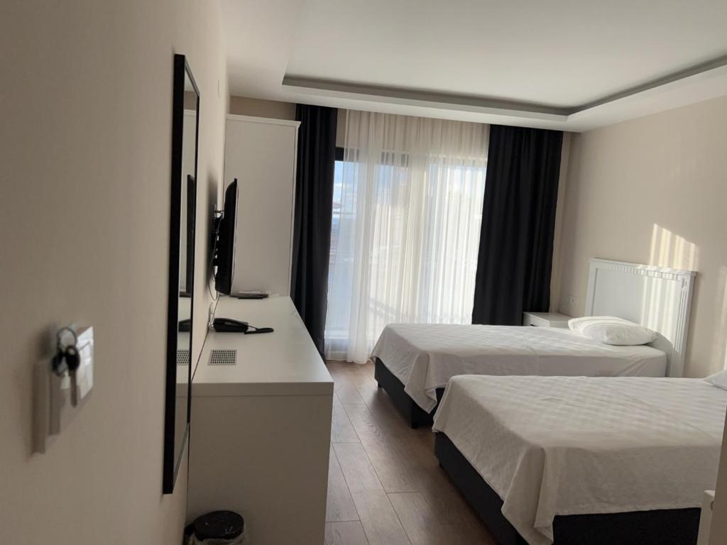 a hotel room with two beds and a television at Dada Otel in Ezine