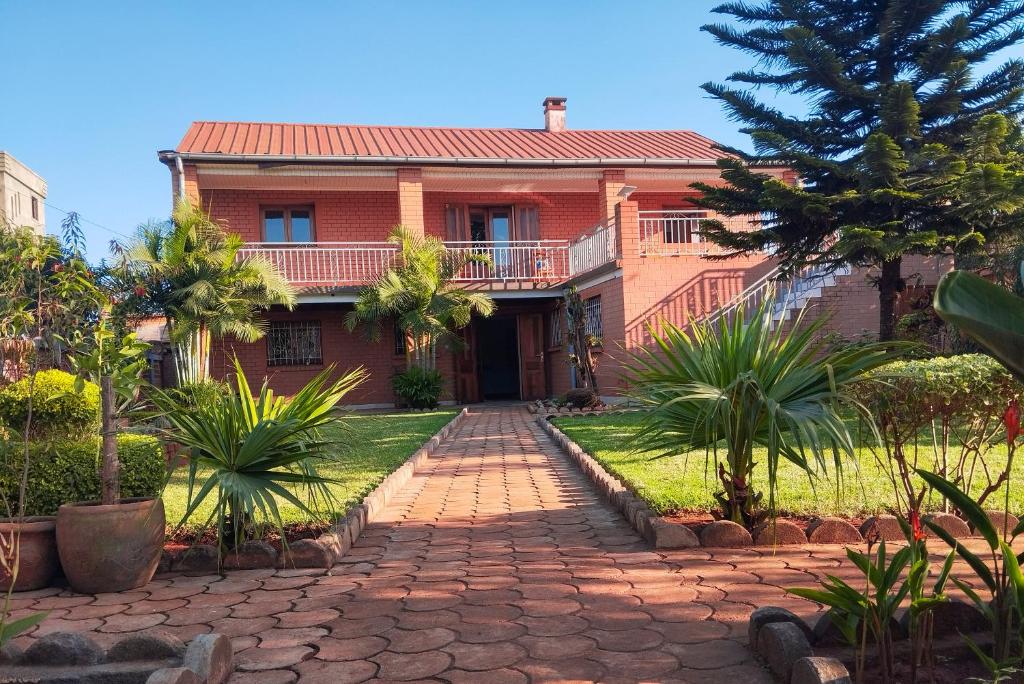 a red brick house with a walkway at Les Jardins d'Areca in Antsirabe