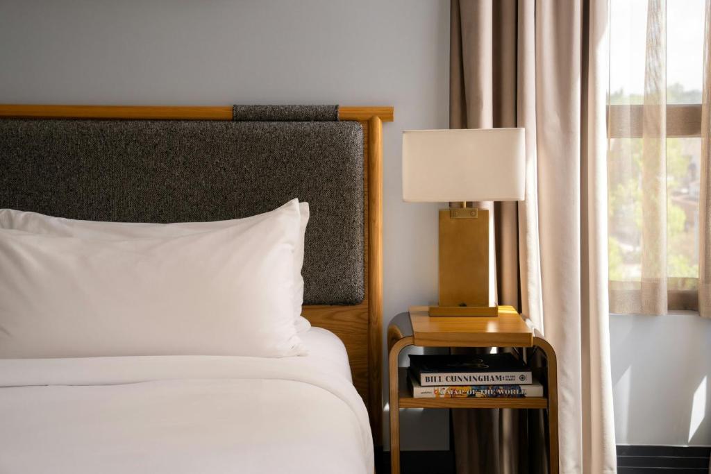 a bedroom with a bed and a table with a lamp at Clayton Hotel & Members Club - Cherry Creek, Denver in Denver