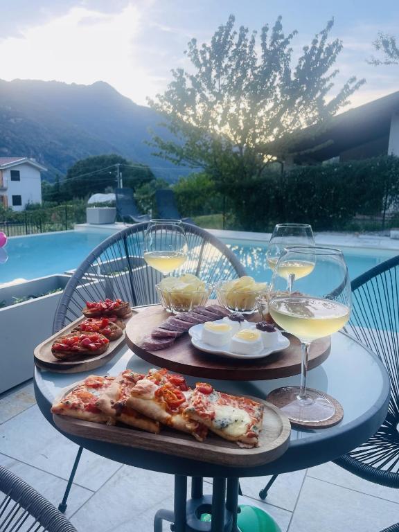 a table with plates of food and glasses of wine at Bed & Breakfast L'Albero Maestro in Borgofranco dʼIvrea