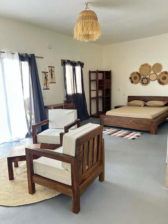 a bedroom with a bed and a chair and a couch at Villa Soa in Nosy Be