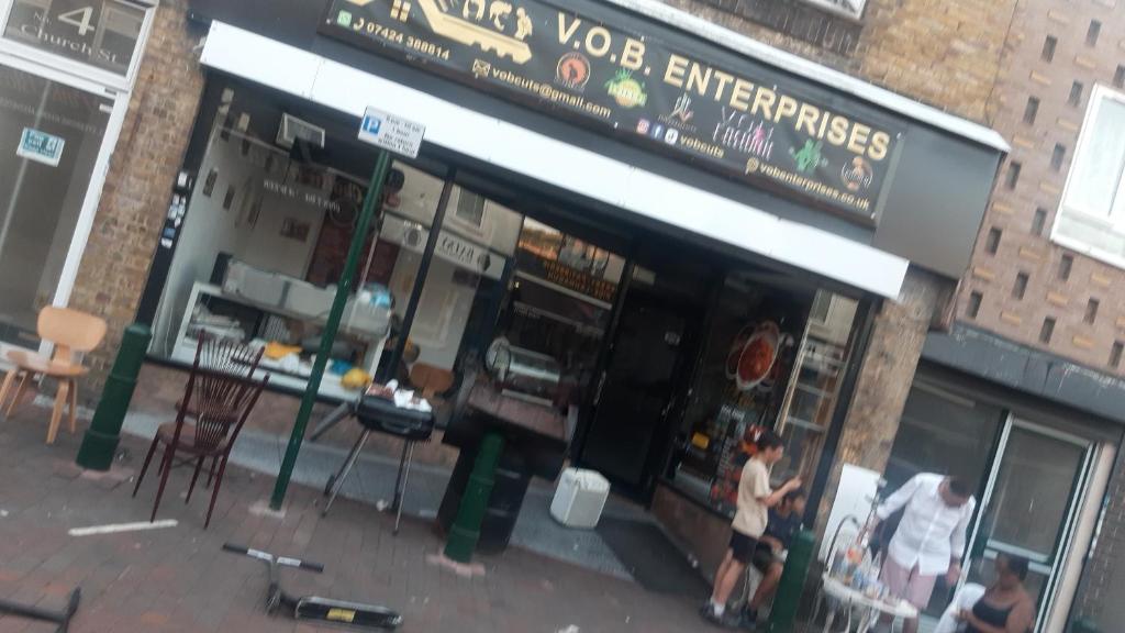 a group of people standing outside of a restaurant at VOB Enterprises in Chatham