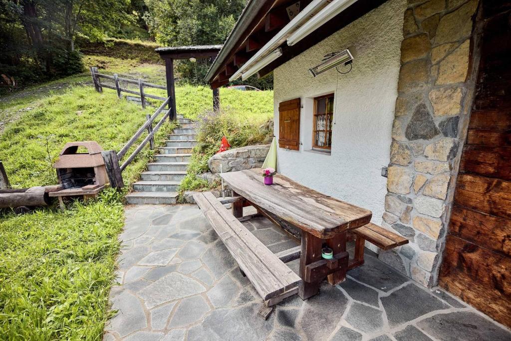 a wooden picnic table sitting outside of a building at Chalet Louchelet in Hérémence