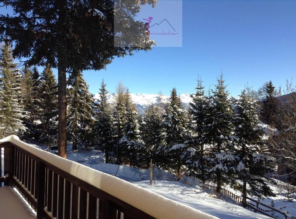 a balcony with snow covered trees and a fence at Chalet Les Rhodos in Vex