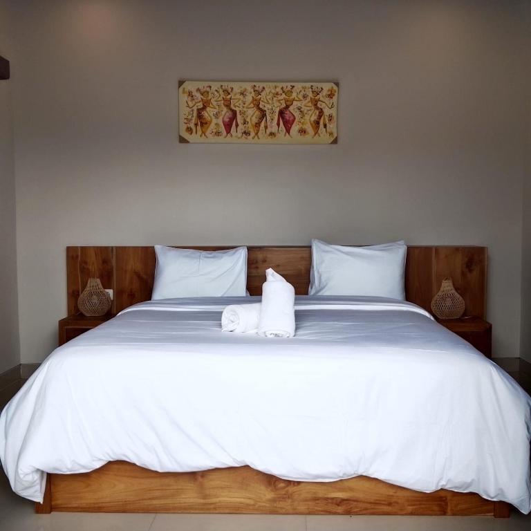 a bed with a white towel on top of it at Villa Gema Laut in Tabanan