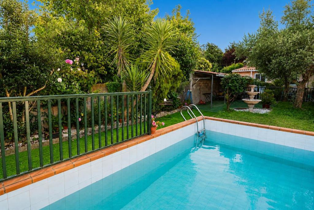 a swimming pool with a fence next to a yard at Casa Maruja O Grove in O Grove