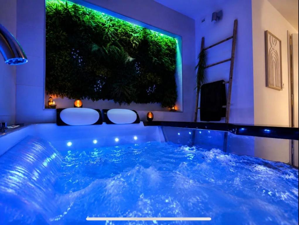 a jacuzzi tub in a room with a green wall at Beau gîte avec jacuzzi in Barr