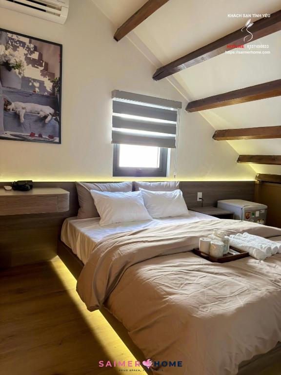 a bedroom with a large bed with a window at Saimer Home in Tân Thành (1)