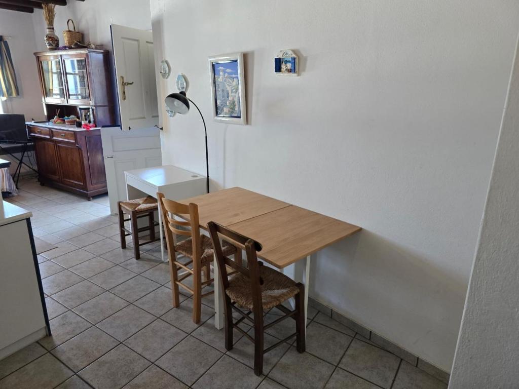 a kitchen and dining room with a wooden table and chairs at Above the Blue in Agios Sostis
