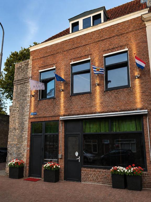 a brick building with flags and flowers in front of it at Boutique Hotel Mare in Middelburg