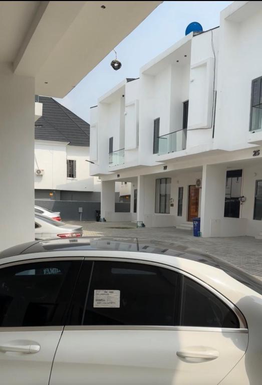 a car parked in front of a building at ZEELUX Apartment in Ikuata
