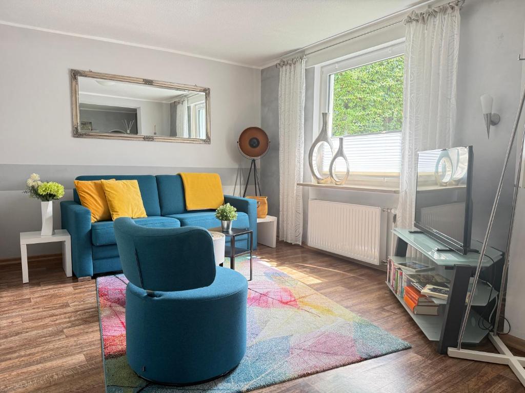 a living room with a blue couch and a tv at Haus Übernachtenswert Cochem Mosel in Cochem