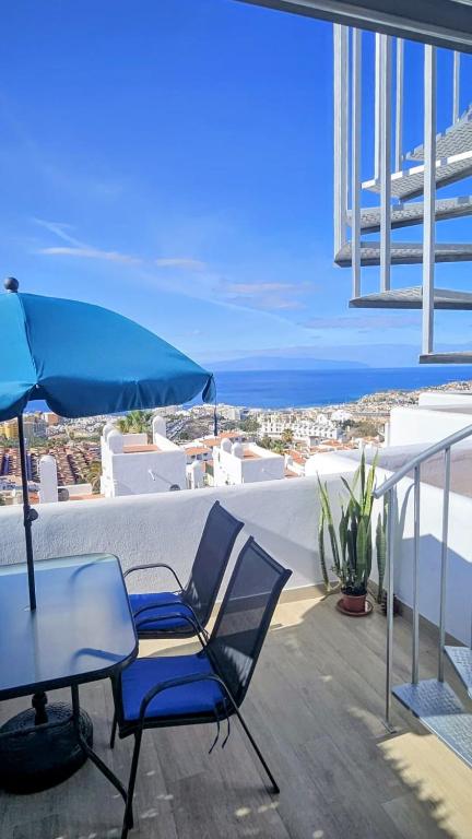 a table and chairs and an umbrella on a balcony at Ocean View Apartments in Adeje