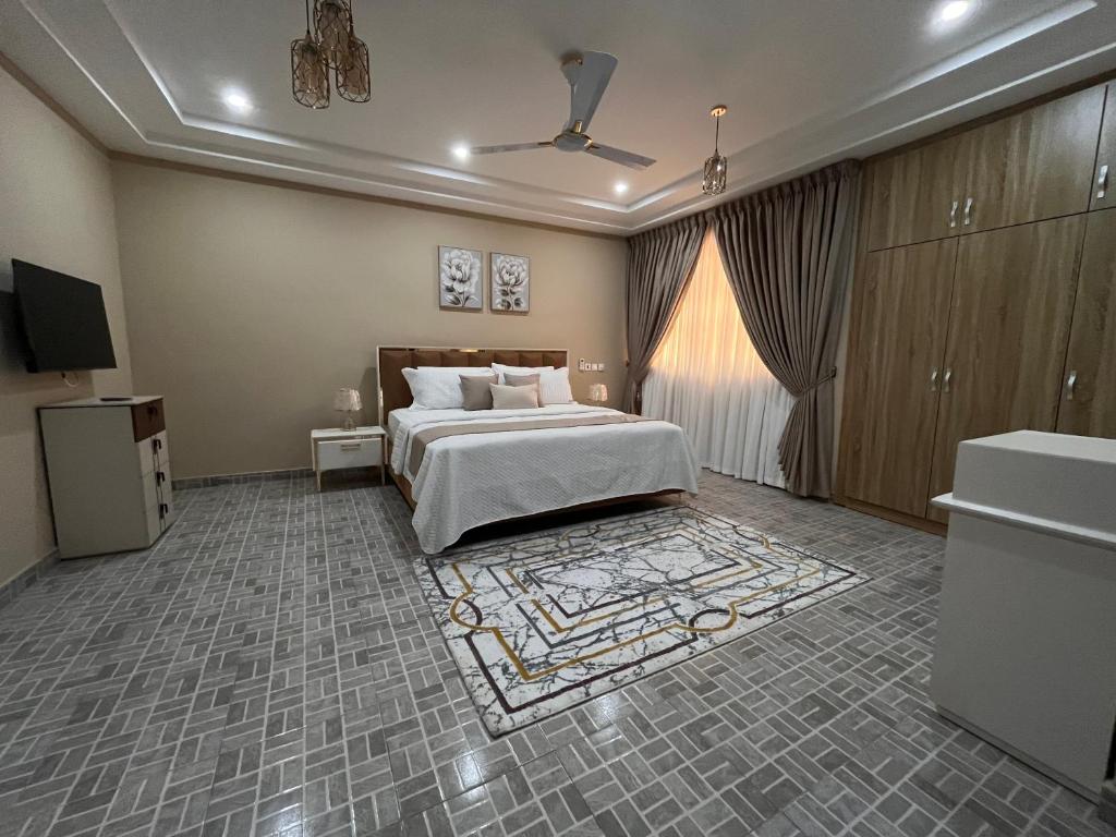 a hotel room with a bed and a television at Modern Three-Bedroom Apartment in Accra