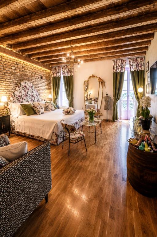 a large bedroom with a bed and a brick wall at Vitrum - Como Luxury Suites in Como