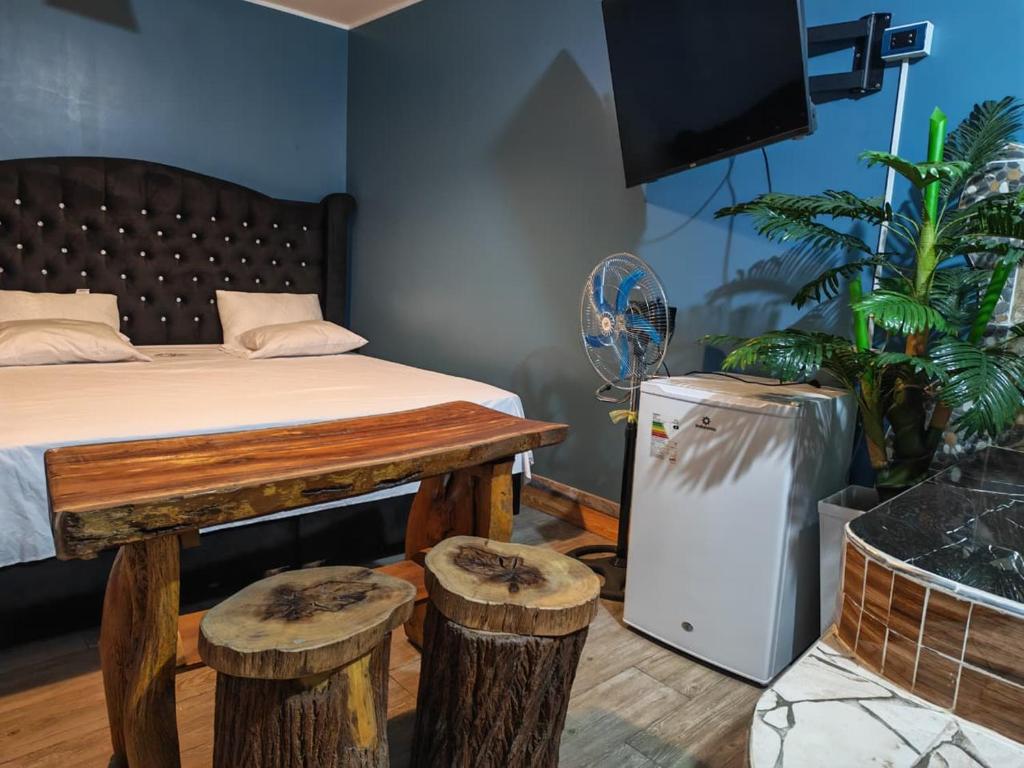 a bedroom with a bed and stools and a tv at Hotel Las Lomas de Pisco in Pisco