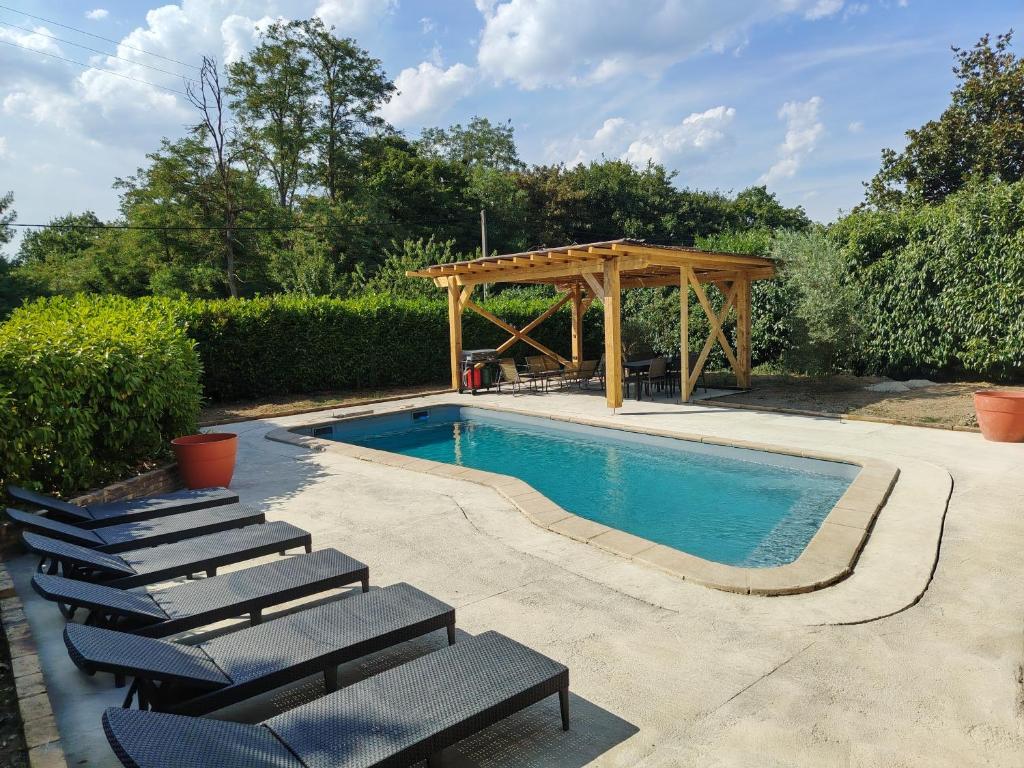 a swimming pool with chairs and a wooden gazebo at Une histoire à écrire in Belleville-sur-Saône