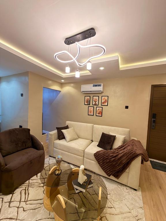 a living room with a couch and a chandelier at Pedro suite by iconic apartment in Lagos