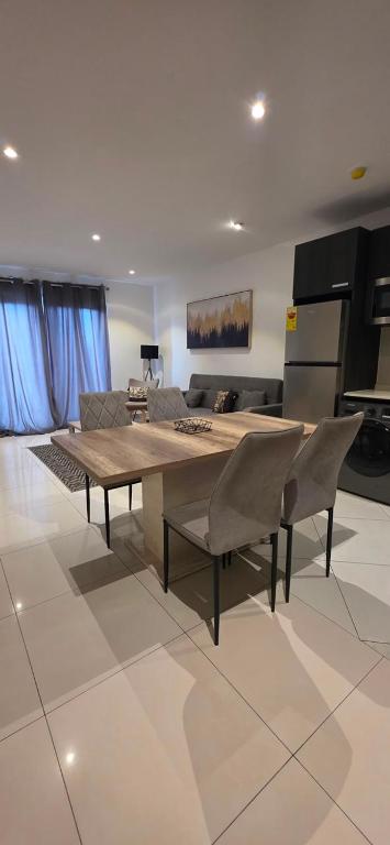 a living room with a table and chairs and a couch at The Lennox Premier Suites in Accra