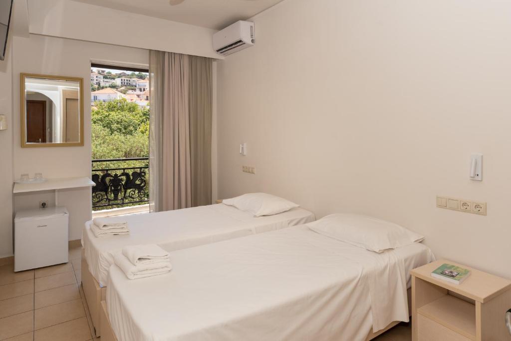 zwei Betten in einem Zimmer mit Fenster in der Unterkunft Galaxy New Hotel in Pylos