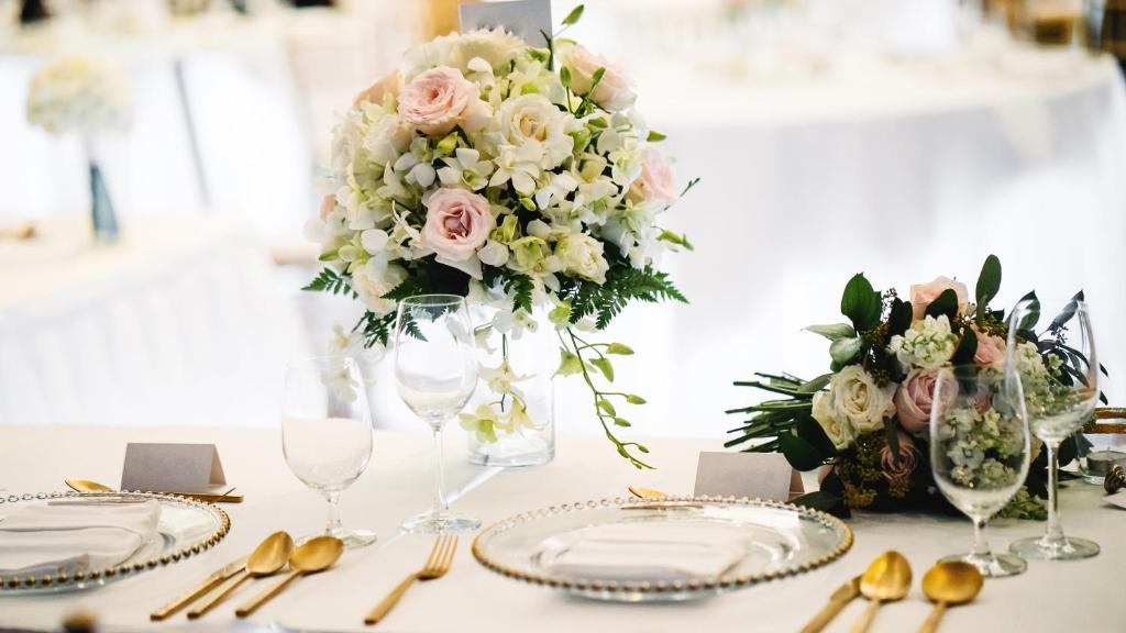 a white table with a vase of flowers on it at InterContinental Lusaka by IHG in Lusaka