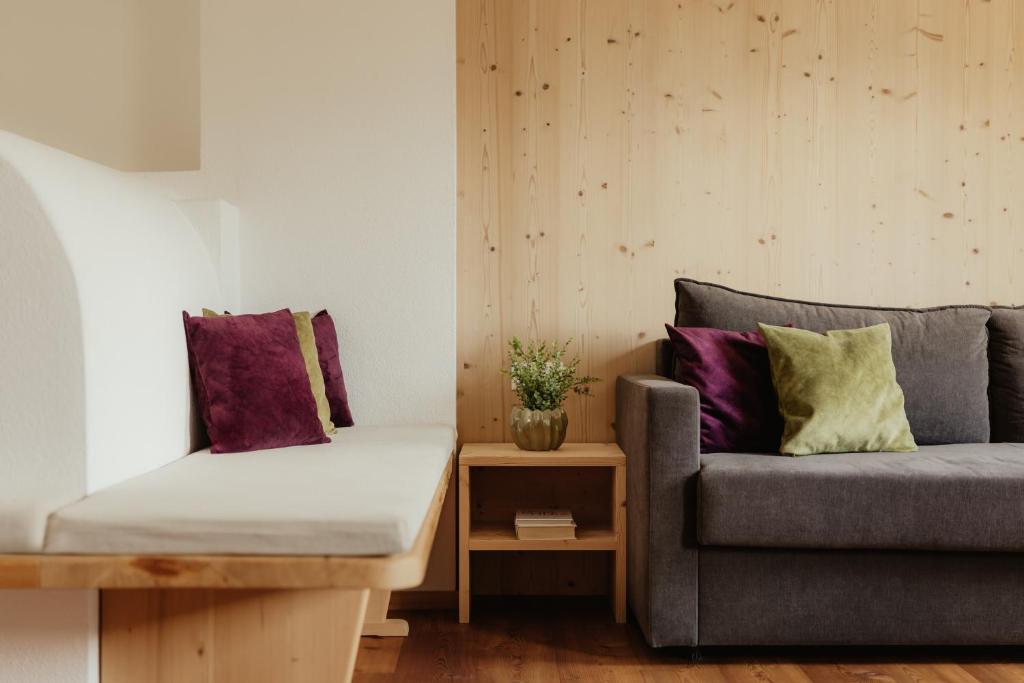 a living room with a couch and a table at New - Penthouse Zirm Untermairhof in Selva dei Molini