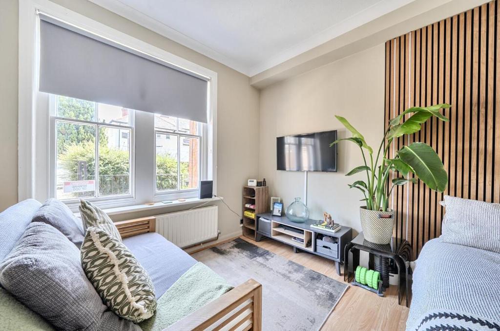 a bedroom with a bed and a large window at Chic Flat Hideaway with Private Courtyard - Pass the Keys in Guildford