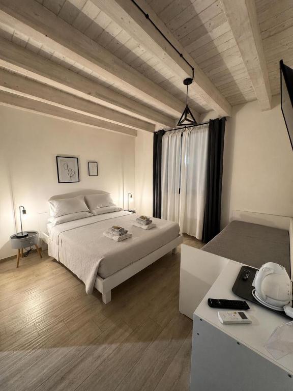 a white bedroom with a bed and a table at Le Quattro Porte in Marsala